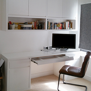 a desk with shelving cabinet above